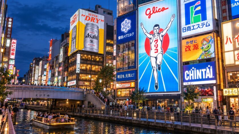 AI-generated photo-style illustration of Dotonbori Canal at blue hour, with the Glico running-man sign and colorful reflections in the water.