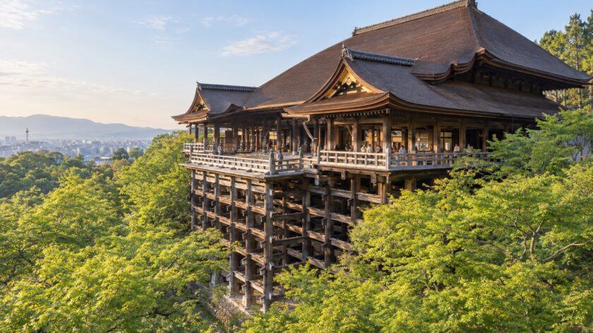 AI-generated photo-style illustration of Kiyomizu-dera’s wooden stage and timber pillars above a green hillside, with Kyoto in the distance.
