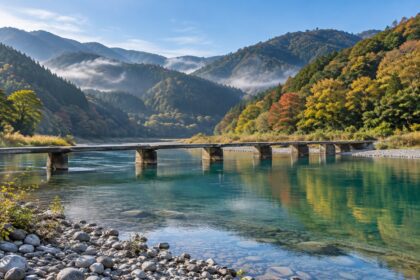AI-generated illustration of a low concrete bridge crossing a clear blue-green river below forested hills, inspired by the Shimanto River in Kochi.