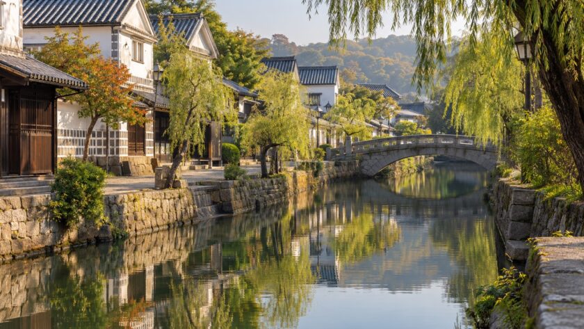 AI-generated illustration of white-walled storehouses, willow trees and a quiet canal, inspired by Kurashiki in Okayama.