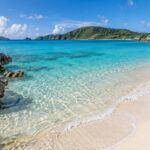 AI-generated coastal illustration inspired by Okinawa, with turquoise water, a white sand beach, and green island hills