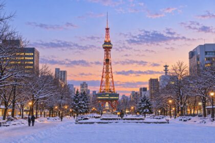 AI-generated illustration of snowy Odori Park and Sapporo TV Tower at dusk, with warm lights beneath a pastel winter sky.