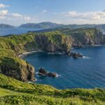 AI-generated illustration of green coastal cliffs and blue sea inspired by the Oki Islands, Shimane.