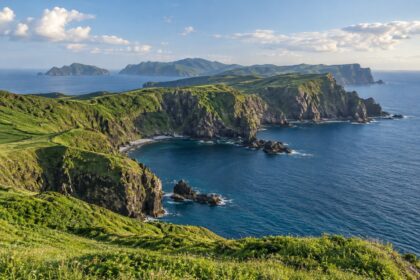 AI-generated illustration of green coastal cliffs and blue sea inspired by the Oki Islands, Shimane.