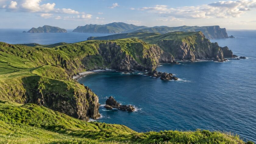 AI-generated illustration of green coastal cliffs and blue sea inspired by the Oki Islands, Shimane.