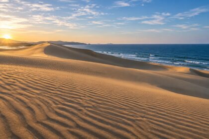 AI-generated illustration of golden coastal sand dunes with wind ripples and a blue sea, inspired by the Tottori Sand Dunes.
