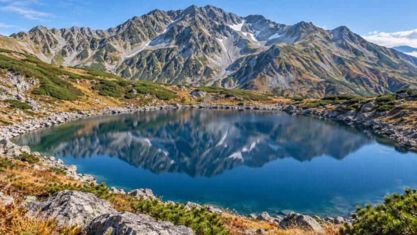 AI-generated illustration of a blue alpine lake and rugged mountains, inspired by Mikurigaike in Tateyama, Toyama, Japan.